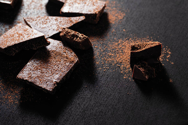 сломанная плитка шоколада на черном фоне
