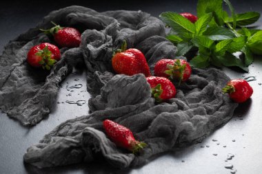 Siyah arka planda taze, olgun kırmızı çilekler.