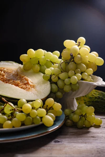 a dish with melon and white grapes on the table