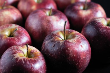 Kokulu kırmızı elmalar arka planda bir sırada uzanır.