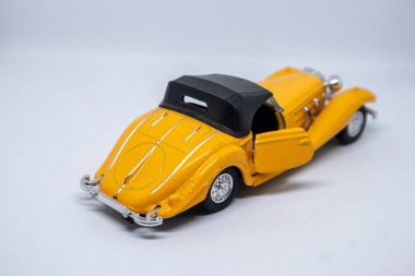 Beyaz arka planda sarı oyuncak araba