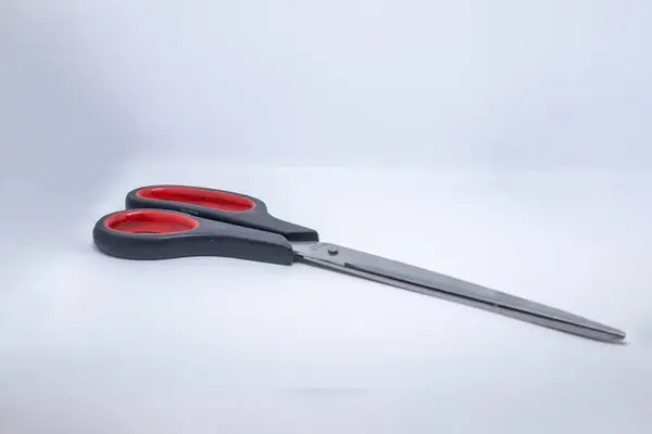 Beyaz arkaplanda kırmızı plastik makas