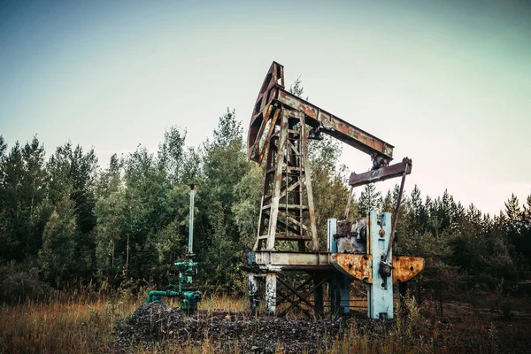 Vieille prise de pompe dans le champ pétrolifère situé dans la forêt — Photo