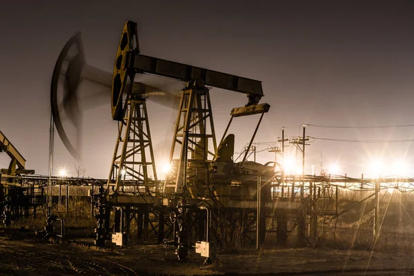 Dolgozó olaj szivattyú jack az éjszaka. — Stock Fotó
