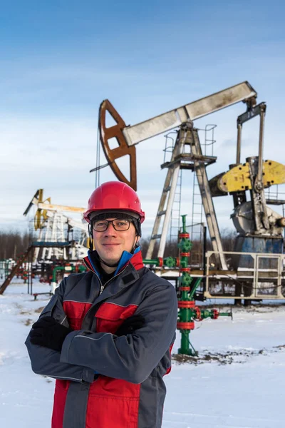 Man worker in the oilfield. Winter period.