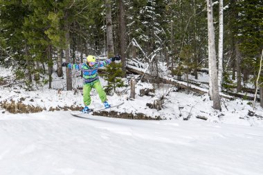 Dağlarda bir orman arka plan üzerinde atlama snowboarder