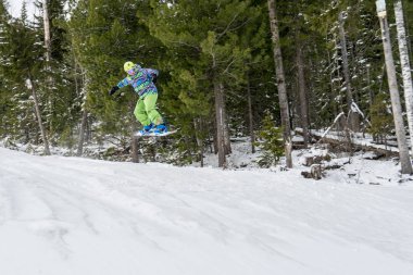 Dağlarda bir orman arka plan üzerinde atlama snowboarder