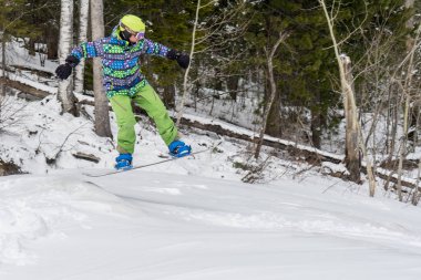 Dağlarda bir orman arka plan üzerinde atlama snowboarder