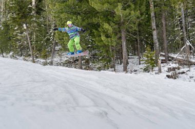 Dağlarda bir orman arka plan üzerinde atlama snowboarder