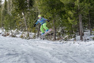 Dağlarda bir orman arka plan üzerinde atlama snowboarder