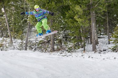 Dağlarda bir orman arka plan üzerinde atlama snowboarder