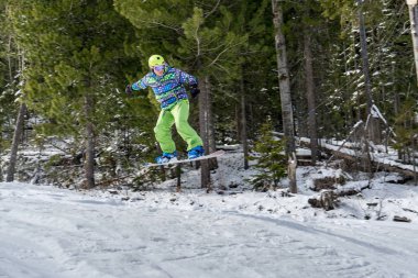 Dağlarda bir orman arka plan üzerinde atlama snowboarder