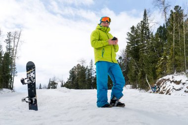 Dağlarda bir orman arka plan üzerinde atlama snowboarder