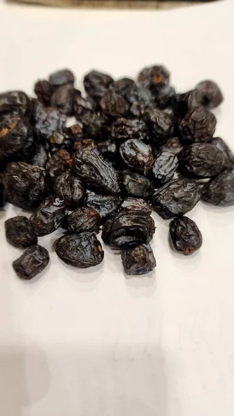 Beyaz arka planda kurutulmuş siyah biber.