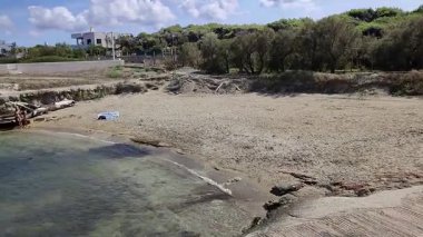 Ostuni, Puglia, İtalya 17 Eylül 2025: Kosta Merlata 'nın engebeli kayalıkları boyunca uzanan küçük altın kumsal