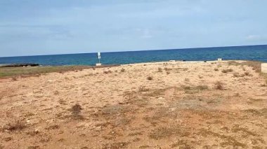 Ostuni, Puglia, İtalya 17 Eylül 2025: Kosta Merlata 'nın engebeli kayalıkları boyunca uzanan küçük altın kumsal