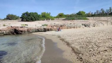 Ostuni, Puglia, İtalya 17 Eylül 2025: Kosta Merlata 'nın engebeli kayalıkları boyunca uzanan küçük altın kumsal