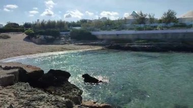 Ostuni, Puglia, İtalya 17 Eylül 2025: Kosta Merlata 'nın engebeli kayalıkları boyunca uzanan küçük altın kumsal