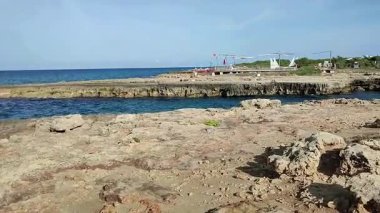 Ostuni, Puglia, İtalya 17 Eylül 2025: Kosta Merlata 'nın engebeli kayalıkları boyunca uzanan küçük altın kumsal