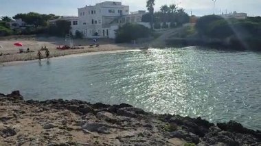 Ostuni, Puglia, İtalya 17 Eylül 2025: Kosta Merlata 'nın engebeli kayalıkları boyunca uzanan küçük altın kumsal