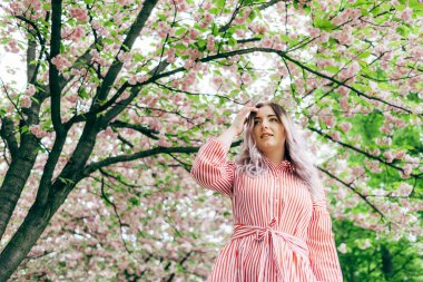 Park güneşli günde kiraz çiçeği mevsiminde zevk güzel genç kadın