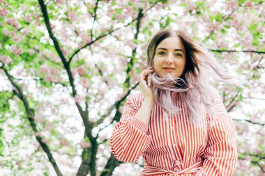 Park güneşli günde kiraz çiçeği mevsiminde zevk güzel genç kadın