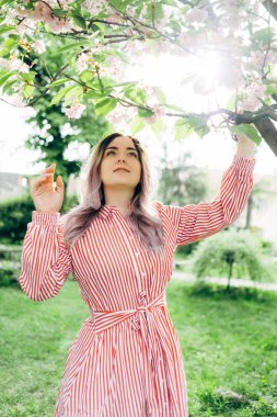 Park güneşli günde kiraz çiçeği mevsiminde zevk güzel genç kadın