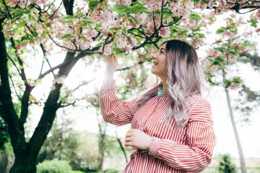 Park güneşli günde kiraz çiçeği mevsiminde zevk güzel genç kadın