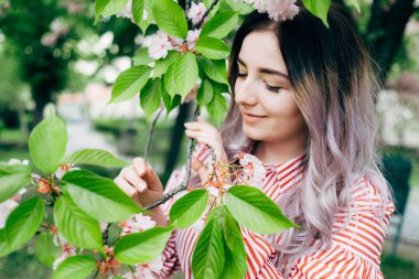 Park güneşli günde kiraz çiçeği mevsiminde zevk güzel genç kadın