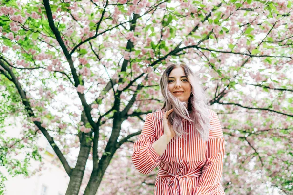 Park güneşli günde kiraz çiçeği mevsiminde zevk güzel genç kadın