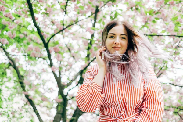 Park güneşli günde kiraz çiçeği mevsiminde zevk güzel genç kadın