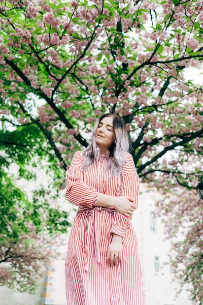 Park güneşli günde kiraz çiçeği mevsiminde zevk güzel genç kadın