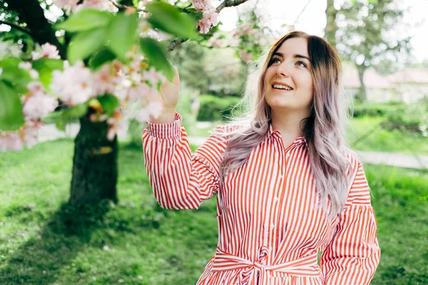 Park güneşli günde kiraz çiçeği mevsiminde zevk güzel genç kadın
