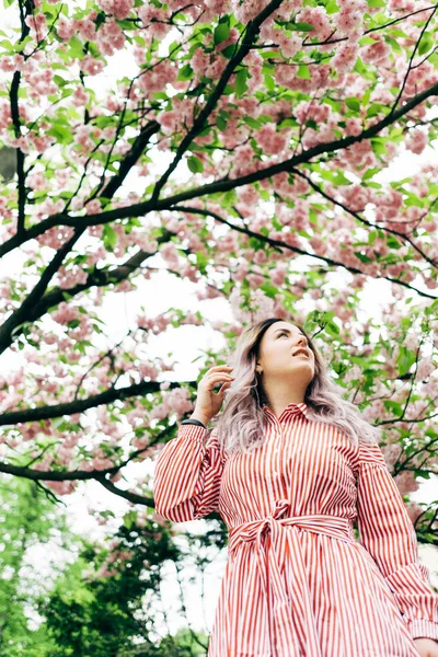Park güneşli günde kiraz çiçeği mevsiminde zevk güzel genç kadın