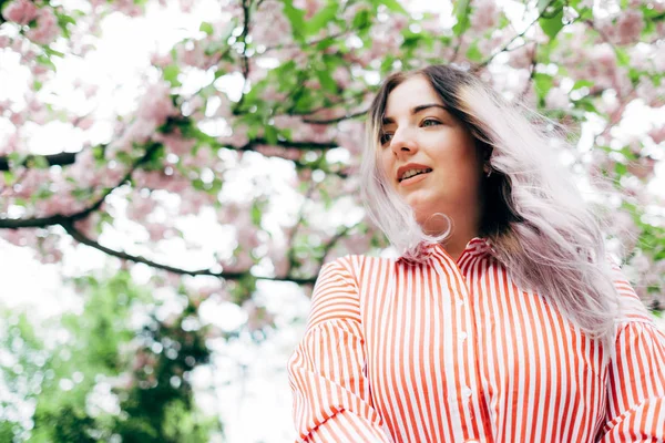 Park güneşli günde kiraz çiçeği mevsiminde zevk güzel genç kadın