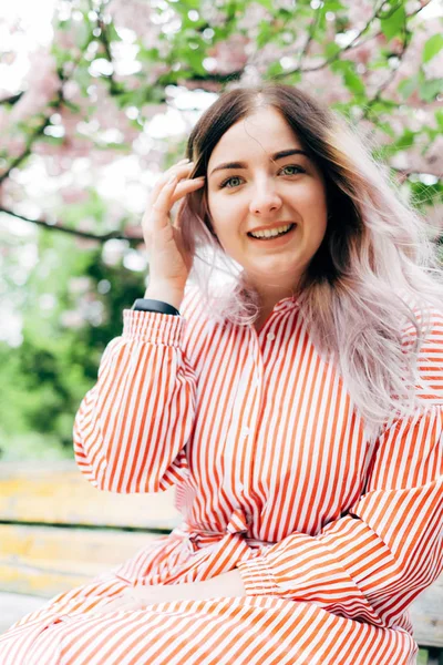 Park güneşli günde kiraz çiçeği mevsiminde zevk güzel genç kadın