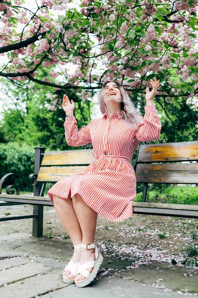 Park güneşli günde kiraz çiçeği mevsiminde zevk güzel genç kadın