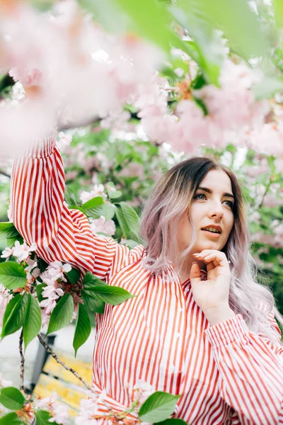 Park güneşli günde kiraz çiçeği mevsiminde zevk güzel genç kadın