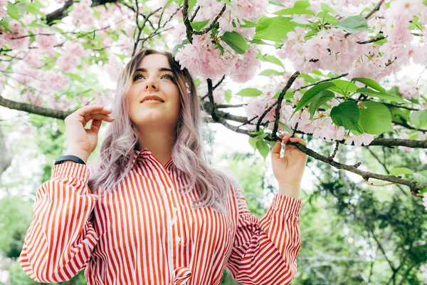 Park güneşli günde kiraz çiçeği mevsiminde zevk güzel genç kadın