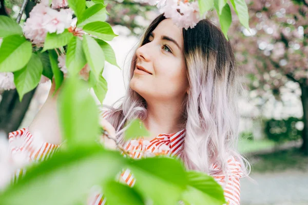 Park güneşli günde kiraz çiçeği mevsiminde zevk güzel genç kadın