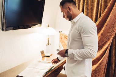 Otel odasında beyaz elbiseli Genç adam