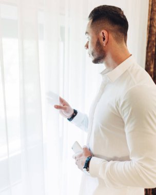 Otel odasında beyaz elbiseli Genç adam