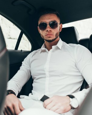 Lüks araba arka koltukta otururken yakışıklı işadamı