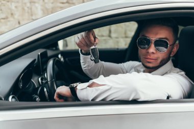 Yakışıklı genç adam onun yeni araba anahtarları gösterilen lüks aracın içinde oturan Auto satın