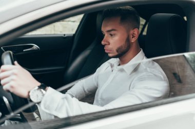 Lüks aracın içinde oturan yakışıklı genç adam