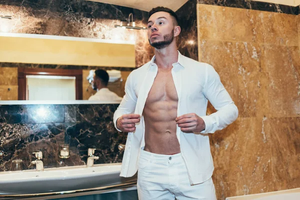 Genç kaslı adam banyoda kalıyorum beyaz gömlekli
