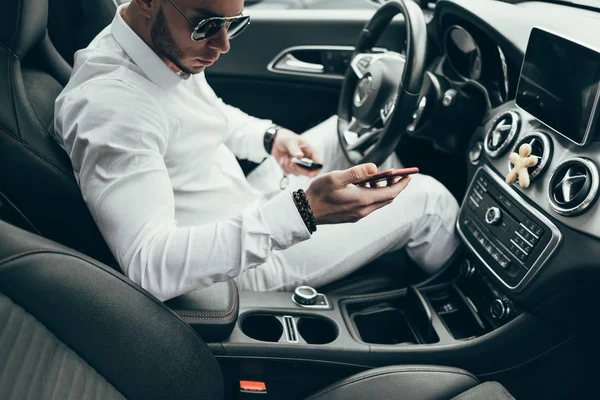 Lüks aracın içinde oturan yakışıklı genç adam