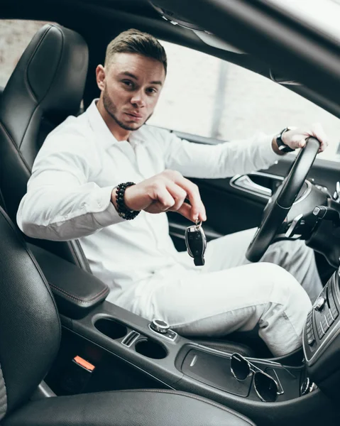 Yakışıklı genç adam onun yeni araba anahtarları gösterilen lüks aracın içinde oturan Auto satın