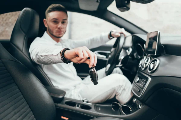 Yakışıklı genç adam onun yeni araba anahtarları gösterilen lüks aracın içinde oturan Auto satın