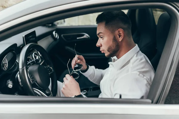 Lüks aracın içinde oturan yakışıklı genç adam